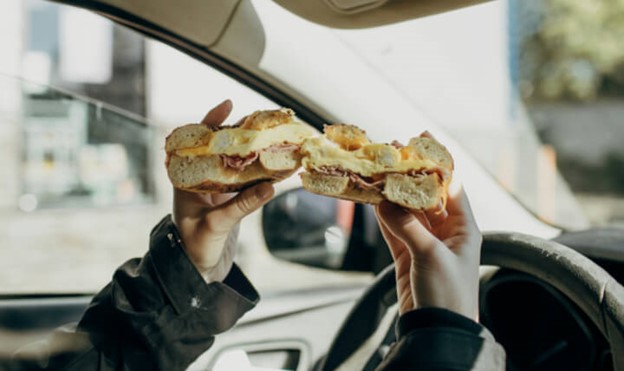 holding bagel inside car
