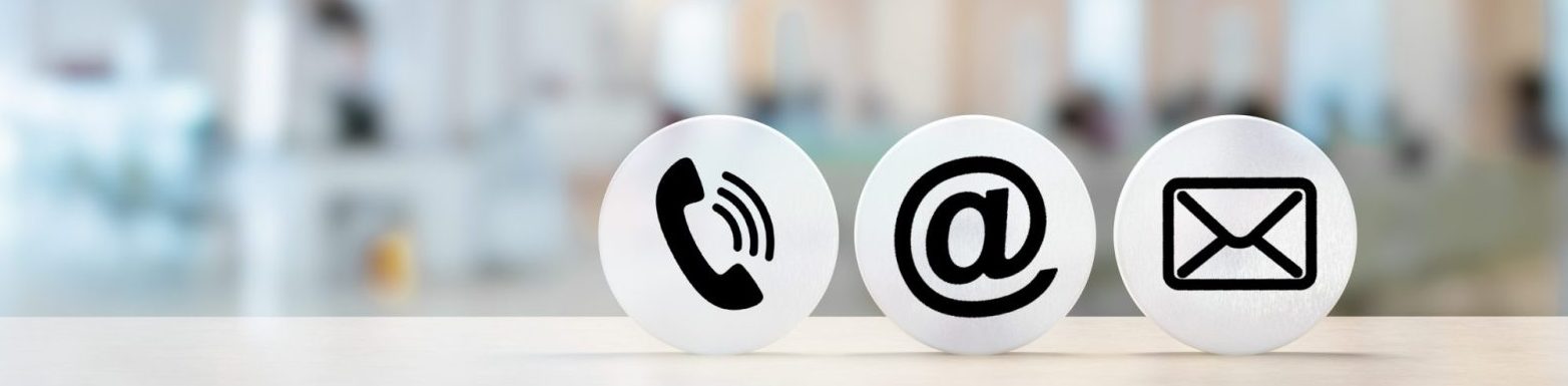 Contact Us. telephone, envelope letter and e-mail symbols on Wooden round in row on table with blurred office background, contact us symbols or web banner